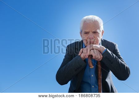 Life seems not so easy. Disappointed sick unhappy pensioner refreshing memories from his life and saddening while sitting in the park