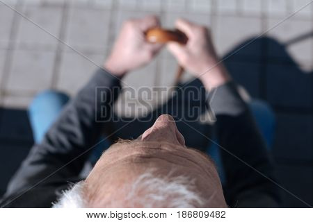 Time flies. Frustrated old sad man thinking about his youthfulness and watching at passerby while having a rest