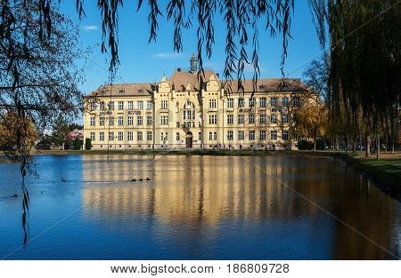 LITOVEL, CZECH REPUBLIC -NOVEMBER 14, 2015: The historic high school building built in 1901 in Litovel, in the mirror of pond by autumn