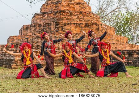 KALASIN THAILAND - FEBRUARY 20 2016: Girl and boy dancers with local dress doing Thai Northeastern traditional dance at Yaku Pagoda to celebrate Buddism event in Kalasin