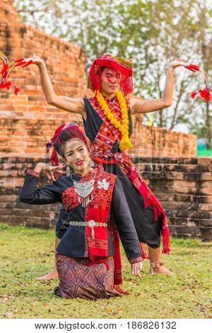 KALASIN THAILAND - FEBRUARY 20 2016: Girl and boy dancers with local dress doing Thai Northeastern traditional dance at Yaku Pagoda to celebrate Buddism event in Kalasin
