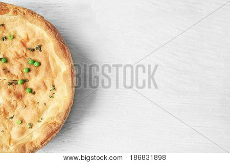 Tasty chicken pot pie on white wooden table