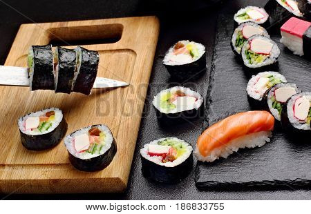 Sushi Cuting On The Wooden Board. Near Set Of Sushi On Stone Board.makki