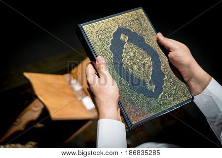 Muslim man hands holding rosary with quraan