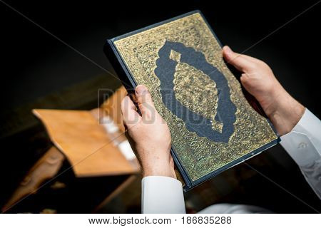 Muslim man hands holding rosary with quraan