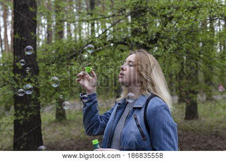 beautiful girl in spring blow bubbles in the Park area