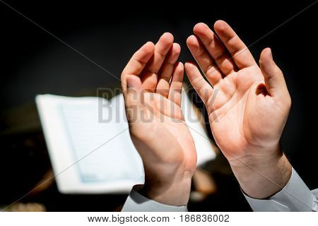 Muslim man hands holding rosary with quraan