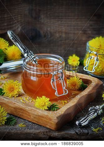 Dandelion jam in a jar and fresh flowers