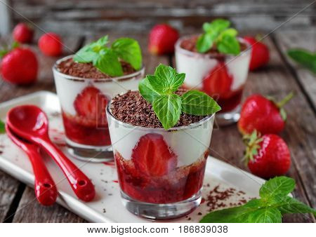 tiramisu with fresh strawberries, chocolates and fresh mint in the glass
