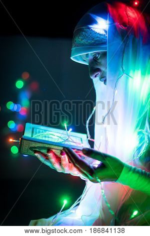 Muslim woman praying in dark room with nice lights around her
