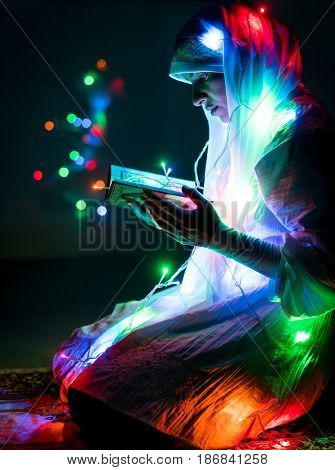 Muslim woman praying in dark room with nice lights around her