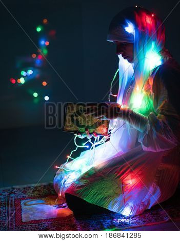 Muslim woman praying in dark room with nice lights around her