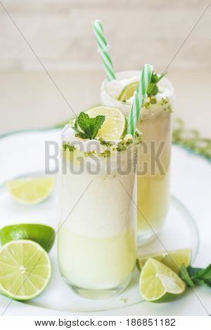 Glasses of fresh Brazilian lemonade or limeade with sugared rim, for summer refreshment. Macro, selective focus, blank space