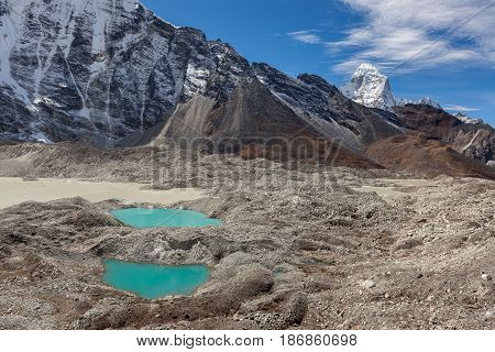 Two Small Moraine Lakes Of Turquoise Color And Snowy Mountain Peaks On The Horizon. Bright Blue Mora