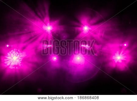 Purple light from the spotlights through the smoke in the theatre during the performance. Lighting equipment.