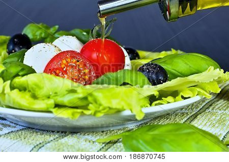 Caprese salad. Classic caprese salad. Italian traditional caprese salad ingredients. Mediterranean food. Caprese salad Tomato and mozzarella with basil leaves on wooden background.