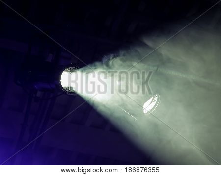 The beam from a searchlight through smoke. Lighting equipment on the ceiling. The stage of a theatre or night club. Show or performance.