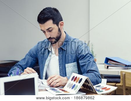 Young man preparing a new decoration project in a coworking espace