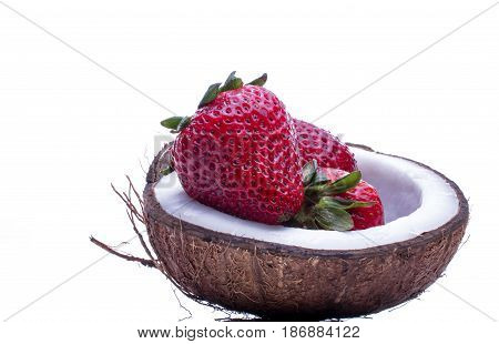 Strawberries in a coconat bowl. Beautiful juicy and bright strawberryes in a bowl of half coconut on white background.  Healthy concept