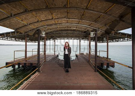 Young girl posing on pier at Lake Siutghiol