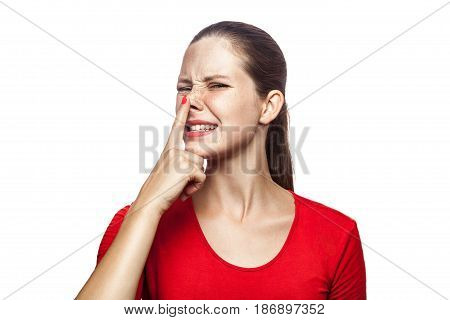 Portrait of liar woman in red t-shirt with freckles. looking up and touch her nose studio shot. isolated on white background.