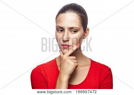 Portrait of thoughtful serious woman in red t-shirt with freckles studio shot. isolated on white background.