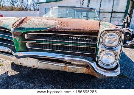 GOSHEN VIRGINIA- APRIL 8 2017: Old car rusting away in front of an abandoned repair shop.