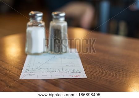 Salt and pepper shakers resting on top of the check