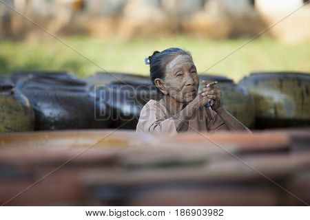 Myanmar, Bagan - 07.11.2011:Old woman smoking a cigar