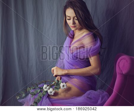 Lovely girl in underwear. Sensual photo. She is in a bikini and a silk scarf. The girl is holding flowers