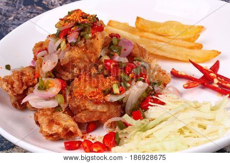 Thai spicy recipe Spicy crispy deep-fried Karaoge chicken salad call Yum Kai Zap in Thai topped sliced cabbage french fried strick and red chili.