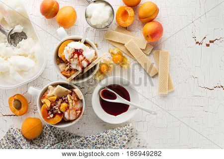 Tasty appetizing ingredients for cooking vanilla ice cream with ice cream spooons and fruits. Top View with Copy Space.