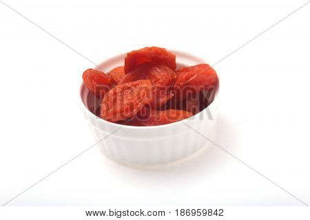 Delicious dried organic apricots on bowl isolated over white background