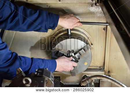 The Worker Installs A New Metal Part In The Chuck Spindles For Processing On The Cnc Machine. Hands 