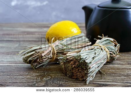 Organic Dry Lemongrass (cymbopogon Flexuosus) In Bunches And Lemon Fruit On A Wooden Table. Herbs Fo