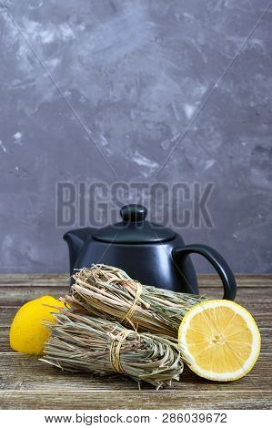 Organic Dry Lemongrass (cymbopogon Flexuosus) In Bunches And Lemon Fruit On A Wooden Table. Herbs Fo