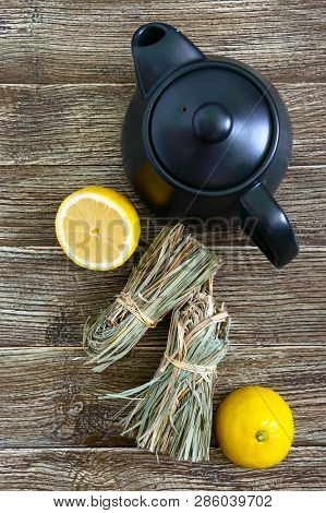 Organic Dry Lemongrass (cymbopogon Flexuosus) In Bunches And Lemon Fruit On A Wooden Table. Herbs Fo
