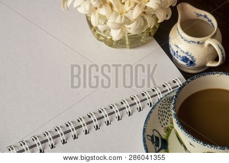 Flowers, Coffee And Notebooks On A Brown Wooden Table That Looks Relax