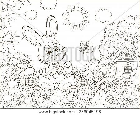 Little Bunny Painting Easter Eggs On Grass Among Flowers On Its Front Lawn Near A Small Hut With Tha