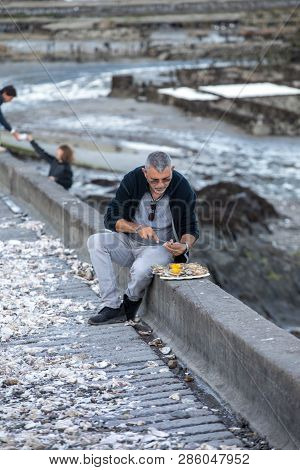 Cancale, France - September 13, 2018: Man Eating Oysters Bought On The Seafront At Cancale, Brittany