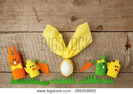 Row Of Funny Easter Bunnies And Easter Egg In Nupkin On Wooden Background, Springtime Concept, Copy 