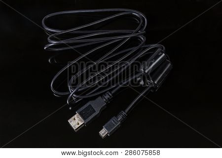 Black Cable With Plugs Usb Standard A And Mini-usb Standard B At The Edges On A Dark Reflective Surf