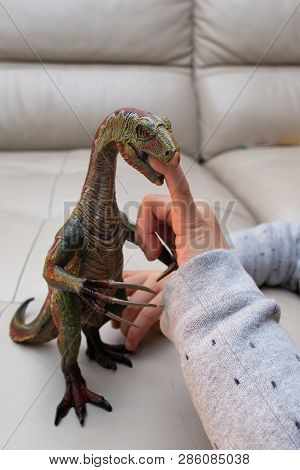 Kid Playing A Nothronychus Toy And Putting His Finger Inside The Mouth