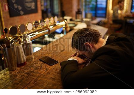 High Angle Portrait Of Mature Businessman Sleeping On Bar Counter Getting Drunk After Work, Copy Spa