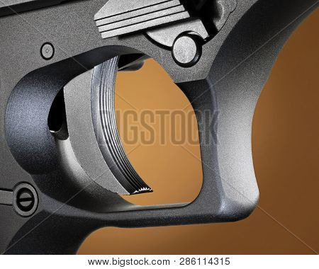 Trigger On A Semi Auto Pistol On A Beige Background