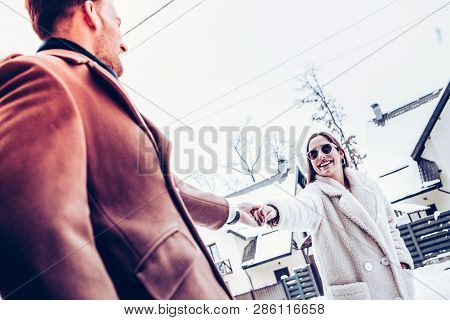 Man Wearing Brown Coat Holding Hand Of Tender Beautiful Wife