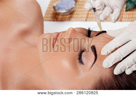 Cosmetology,plastic Surgery,beauty Concept. Beautiful Woman Face And Hand In Glove With Syringe Maki