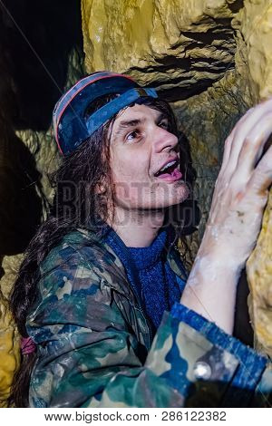 Man Explores Narrow Passage In The Cave