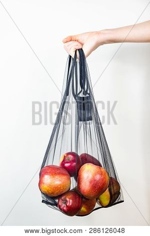 Holding A Reusable String Bag Full Of Apples. Sustainable Eco Packaging Concept: Shopping For Grocer