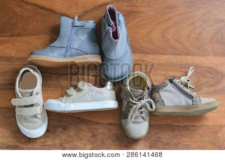 Different Girls Shoes On A Wooden Background